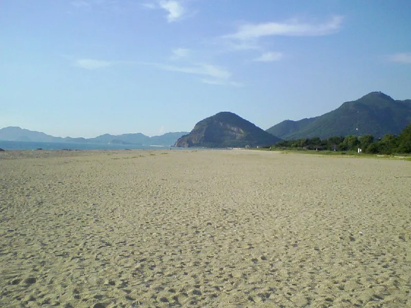 広い白砂が続く有明浜と遠くの山並み