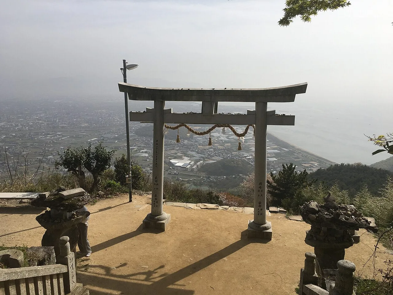 高屋神社本宮の鳥居越しに見える観音寺の街と海